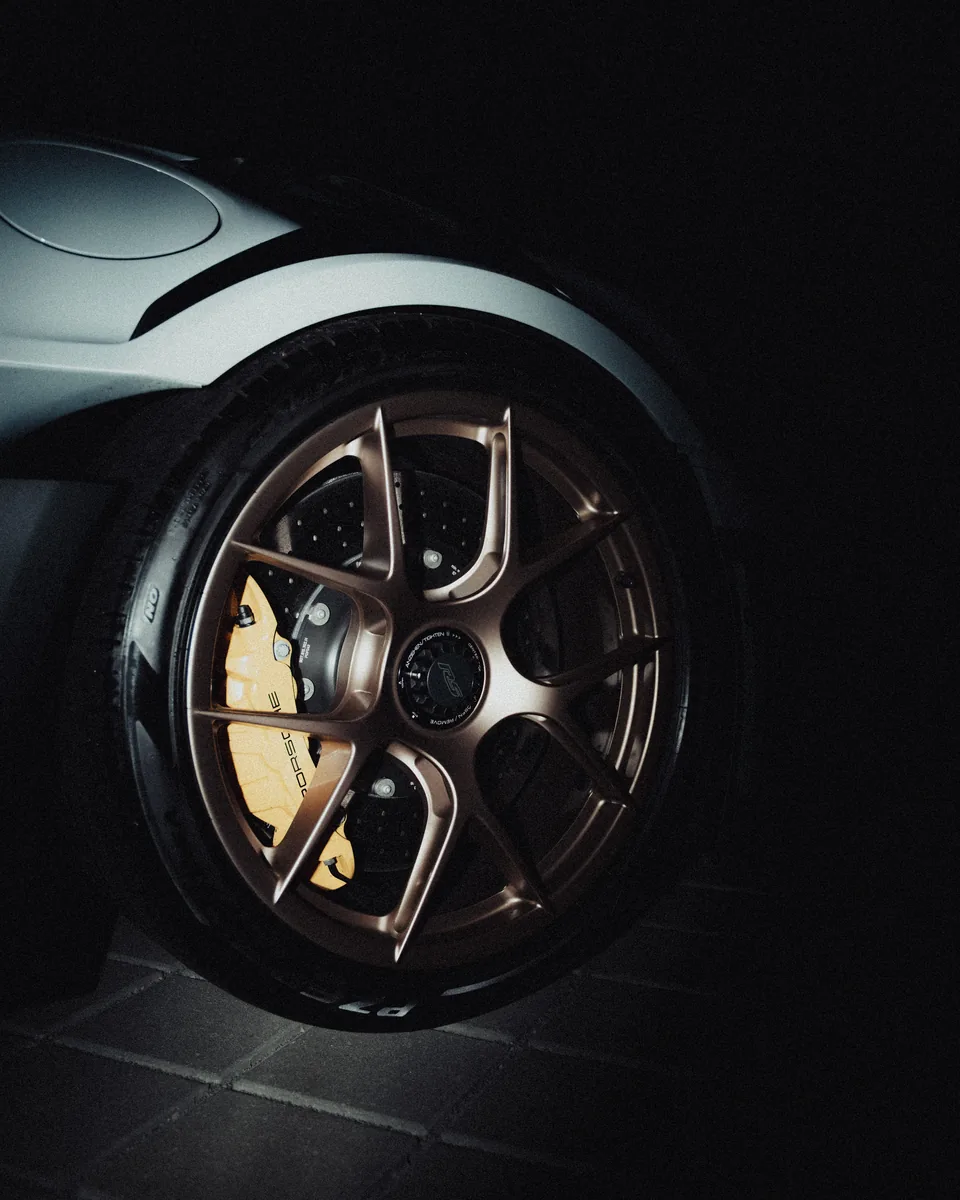 Porsche-Rad mit goldener Felge und Bremssattel
